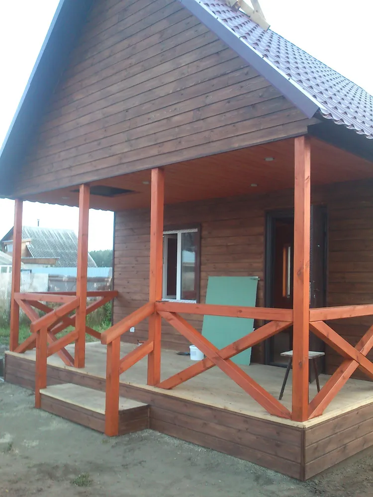 На веранде установлены перила и сделано небольшое крылечко.