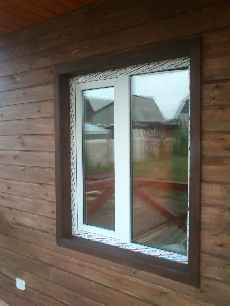 Стекло пакеты отделаны наличниками в цвет углов и кровли.