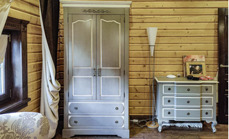 Шкаф для одежды двухстворчатый с ящиками и верхним декором.