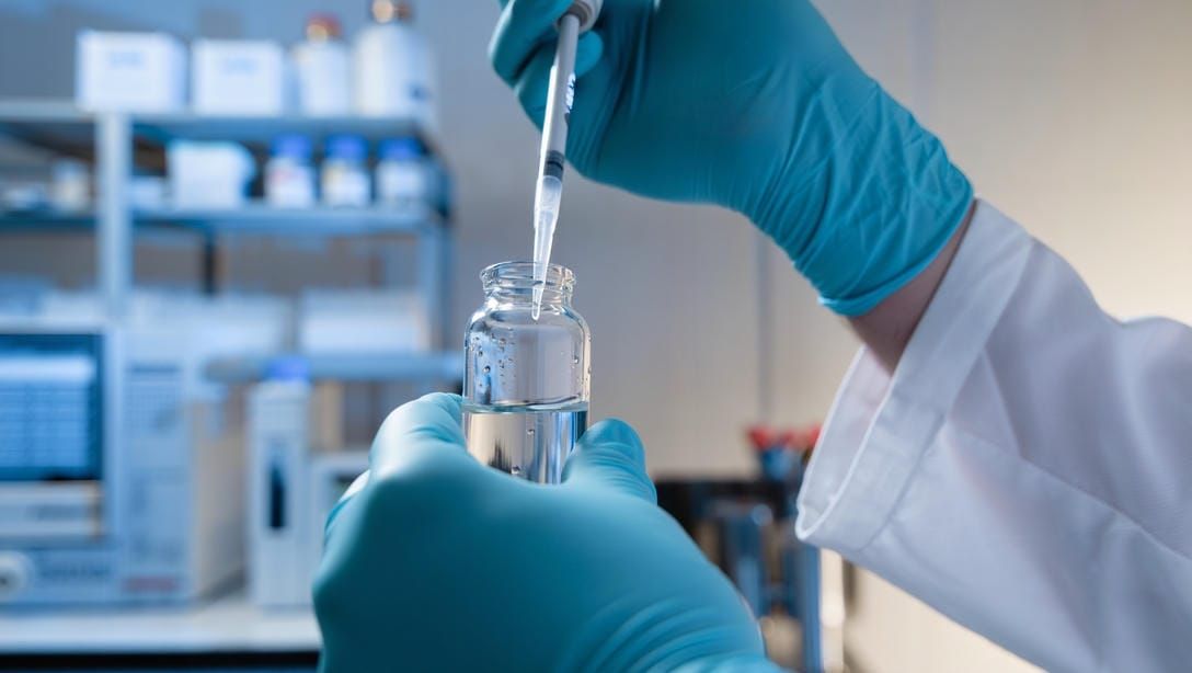 Лаборант набирает пробу воды для анализа Cr(VI) в аналитической лаборатории