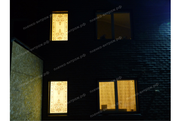 Витражная пленка на окнах. Фото фасада дома ночью.