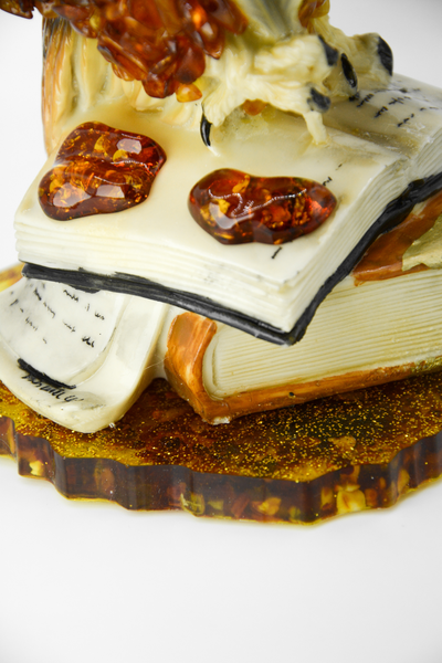 Сова с пером на книгах на подставке