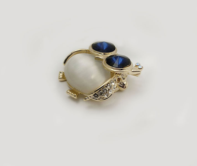 (АРТИКУЛ: 7038/81) БРОШКА ЖЕНСКАЯ "СОВА", СРЕДНЕГО РАЗМЕРА, МЕТАЛЛ , СТРАЗЫ, ЮВЕЛИРНОЕ СТЕКЛО, ЦВЕТ ЗОЛОТИСТO-ЖЕМЧУЖНЫЙ С СИНИИ КРИСТАЛЛАМИ