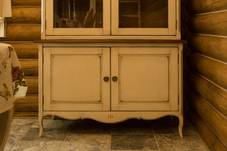 Витрина с двумя стеклянными дверьми и нижней тумбой.