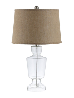 Настольная лампа с бежевым абажуром и основанием в виде прозрачного кубка.