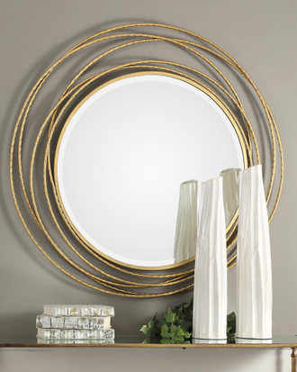 Зеркало круглое в обрамлении золотых металлических колец.