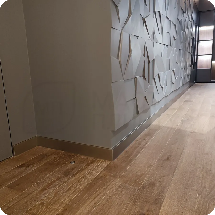 Теплый акцент: установка плинтуса Dollken в бронзовом цвете создает уютный и роскошный акцент в современном интерьере.