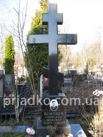 На фото памятник в виде черного гранитного креста на могилу в СПб