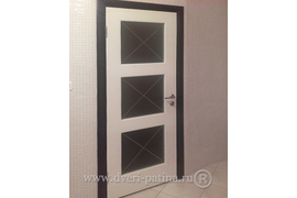 Белая дверь  эмаль "Прима 33 Ф"  матовое стекло с перекрестиями. Установлена в ванной комнате загородного дома Подольского района. Декорирование черным наличником с дверными ручками Арчи.
