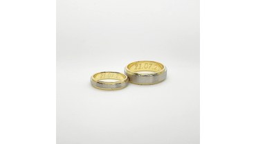 Обручальные кольца из белого и желтого золота с матовой поверхностью и гравировкой.