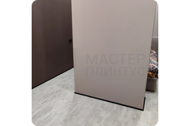 Элегантный минимализм в действии: монтаж тонкого черного плинтуса Dollken WLK 20, который идеально подчеркивает современный интерьер.