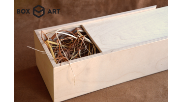 3053 Пенал подарочный для бутылки 
Материалы: березовая фанера 6 мм
Наполнение: натуральный пальмовый лист (рафия)
Возможно нанесение логотипа, изображения или поздравительного текста с помощью гравировки.
Размеры: 10х10х32 см (можно изменять)