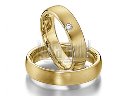 Классические обручальные кольца из желтого золота с бриллиантом у края женского кольца
