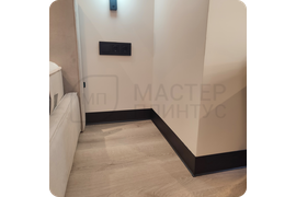 Современный дизайн в деталях: монтаж черного алюминиевого плинтуса ПЛ 100 с эффектным муаровым покрытием.