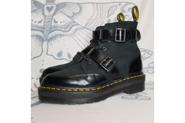 Черные ботинки DR. Martens из натуральной кожи украшены ремешками и представлены в размере от 36 до 45.