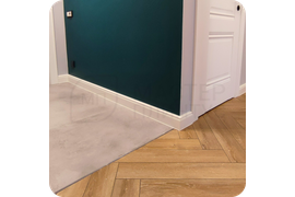 Имперская роскошь: монтаж белого плинтуса Dollken Hamburg Style 80 создает величественный образ помещения, вдохновленный классическими европейскими интерьерами с изысканными архитектурными деталями.