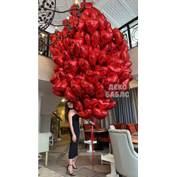 Огромная охапка из сотен красных фольгированных сердец с гелием, закрывающая человека в полный рост