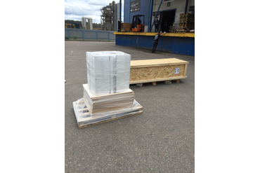 Пример жесткой упаковки, которую мы используем для перевозки стеновых панелей и штапика из массива дерева длиной 2,2 метра - изготовленный деревянный ящик, выставленный на паллеты. Также, виден пример упаковки других стеновых панелей.