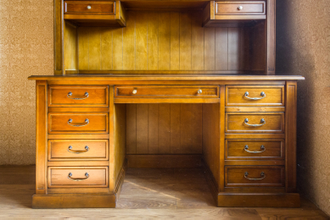 Письменный стол с высокой надстройкой с полками и ящиками.