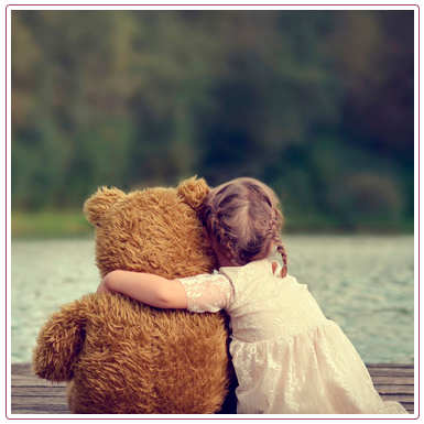 девочка обнимает плюшевого медведя