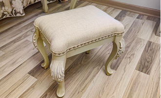 Пуф с мягким сиденьем на резных ножках.