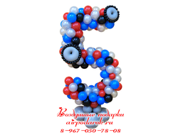 Плетеная цифра 5 из шаров выполнена в расцветках трансформеров, оформленная декоративными колесами