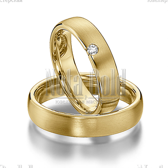 Классические обручальные кольца из желтого золота с бриллиантом у края женского кольца