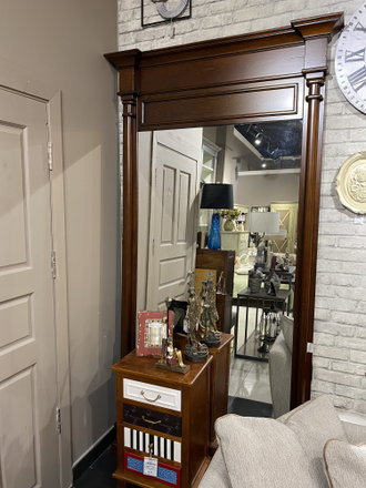 Большое напольное зеркало с верхним карнизом.