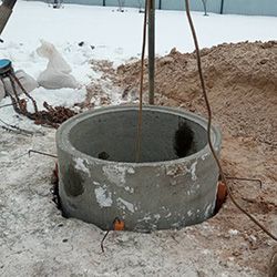 Опускание и установка колец в шахту колодца.