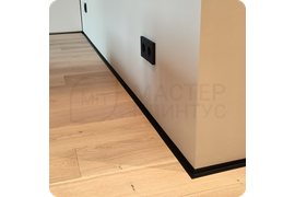 Изящный переход: монтаж тонкого черного плинтуса Dollken WLK 20 для создания плавного перехода между поверхностями.