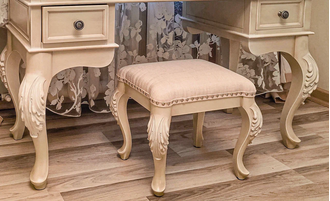 Пуф с мягким сиденьем на резных ножках.