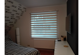 Рулонная штора Зебра в приоткрытом положении в гостевой комнате.