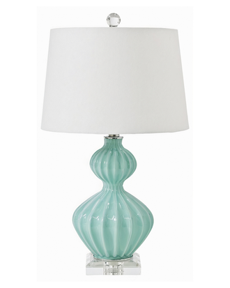 Настольная лампа c бирюзовым основанием и белым абажуром.