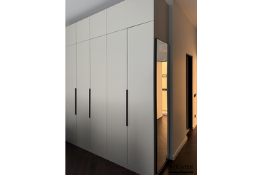 066 Шкаф с распашными дверями.Торцевая стена оформлена зеркалом в узком рамочном профиле черного цвета. Фасады ЛДСП Egger U750 ST9 Ярко-серый