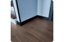 Гибкое решение: монтаж универсального черного плинтуса Dollken Cubu Flex Life 80, идеально подходящего для помещений любой формы.