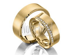 Классические обручальные кольца из желтого золота с полоской бриллиантов у края женского кольца