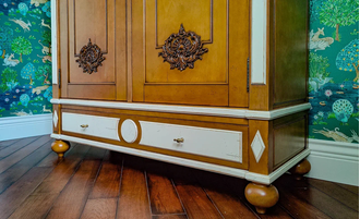 Шкаф для одежды с резным декором на фасадах и нижним ящиком.