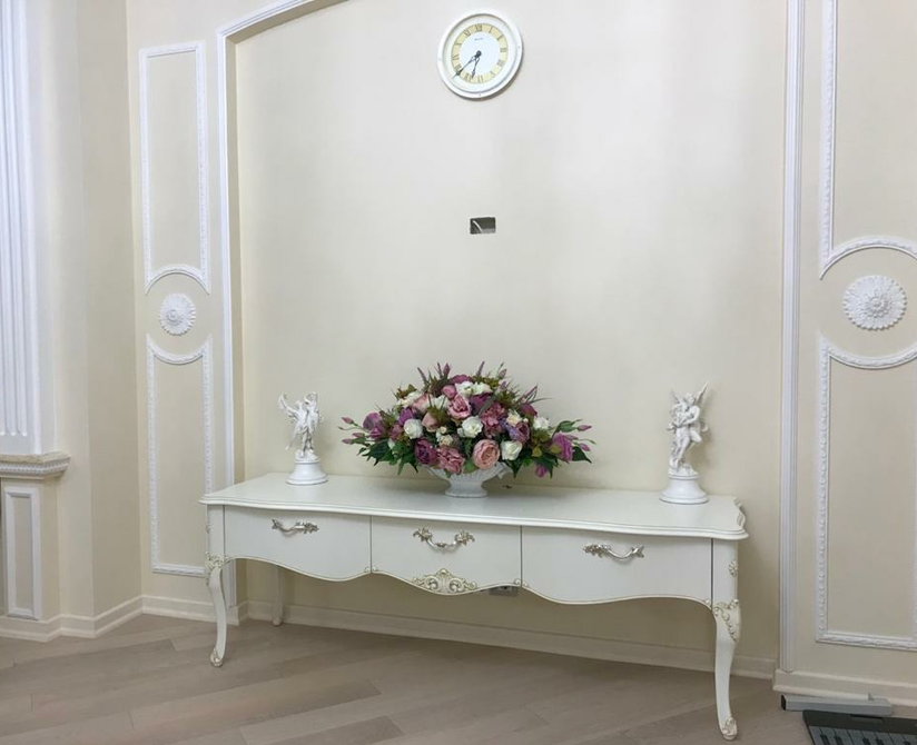 Композиция из искусственных цветов удлинённая в вазе ладье, в белом интерьере