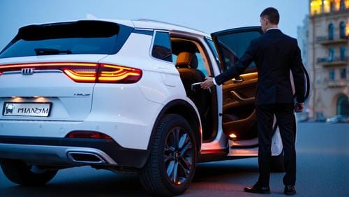 Профессиональный водитель открывает дверь роскошного автомобиля в Тюмени.