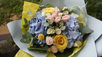 Солнечный букет из живых цветов в желто-голубой гамме из голубой гортензии, желтых роз и эвкалипта,