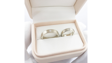 Парные обручальные кольца из белого золота с одним бриллиантом и матовой поверхностью.