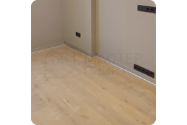 Фото процесса монтажа плинтуса ПЛ 100 «серебро», демонстрирующее его простоту и удобство.