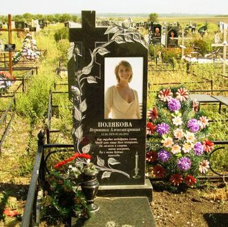 На фото памятник в форме креста обвитого розами на могилу в СПб