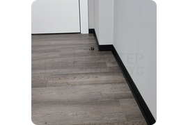 Визуальная гармония: монтаж черного плинтуса Dollken S60 обеспечивает гармоничное сочетание с различными стилями интерьера, создавая сбалансированный образ.