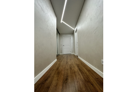 белый матовый натяжной потолок со встроенными светодиодными светильниками в виде полос