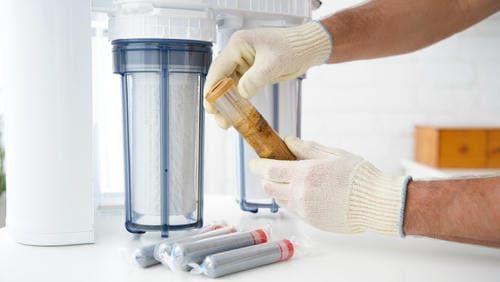 Замена картриджа в системе водоочистки, руки специалиста