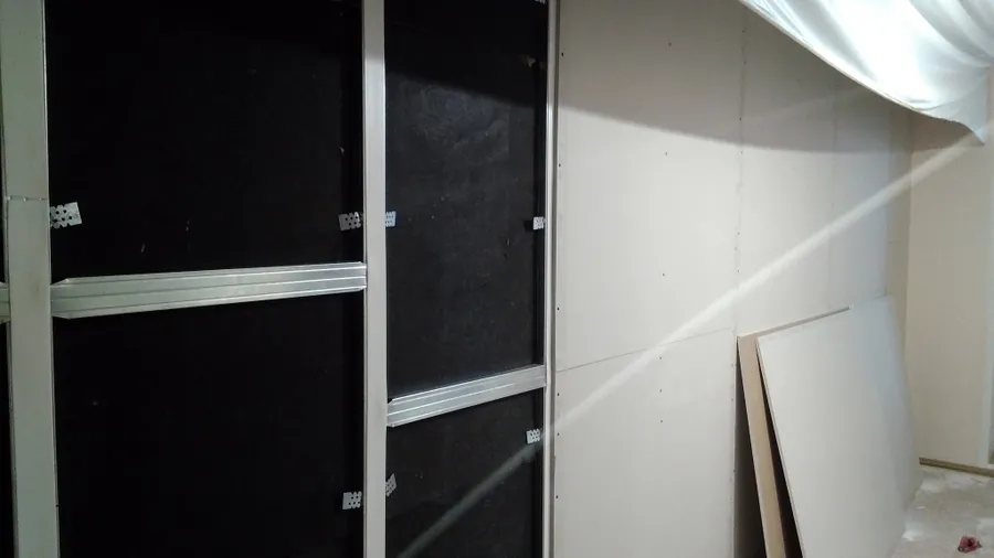 В систему звукоизоляции стены входят: "ТЗИ 14мм"=>"Виброподвес"=>"Плиты СтопЗвук БП Премиум 50мм"=>Металлокаркас с поклейкой демферной ленты "Стопзвук"=>Два слоя "ГКЛ 9,5 и 12,5мм,  герметизация и поклейка ленты "Соноплат" на стыках