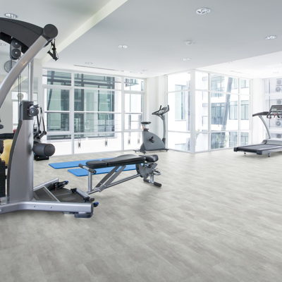 Виниловый пол Wineo 400 Stone Wisdom Concrete Dusky DB00140 в интерьере спортивного центра