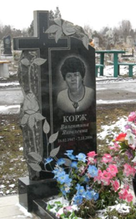 Фото вертикального бюджетного памятника на могилу с гравировкой цветов и креста в СПб