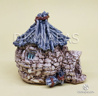 Каменный домик с крышей из веток